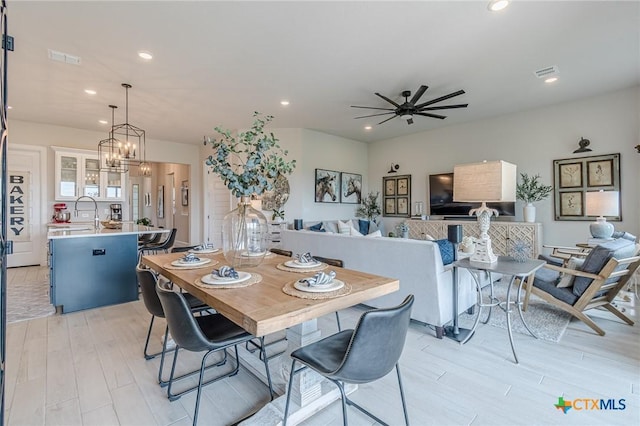 1308 Dancing Oak Ln, San Marcos, TX 78666 - dining room featuring light wood-type flooring, recessed lighting, ceiling fan, and a chandelier