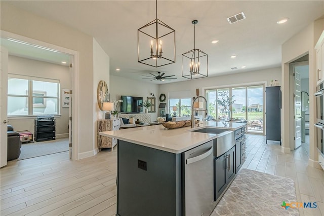 1308 Dancing Oak Ln, San Marcos, TX 78666 - kitchen featuring dishwasher, a chandelier, open floor plan, an island with sink, and pendant lighting
