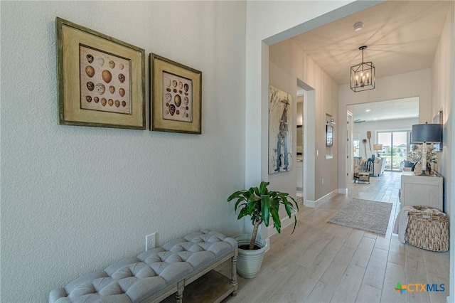 1308 Dancing Oak Ln, San Marcos, TX 78666 - hallway featuring a chandelier and light wood-style floors