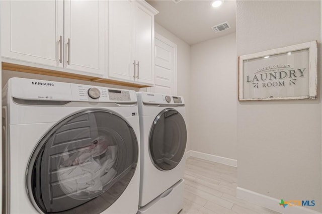 1308 Dancing Oak Ln, San Marcos, TX 78666 - laundry area with washing machine and dryer, cabinet space, and light wood-type flooring
