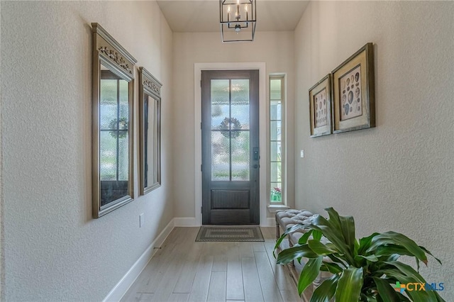 1308 Dancing Oak Ln, San Marcos, TX 78666 - entryway featuring healthy amount of natural light, wood finished floors, a textured wall, and a chandelier