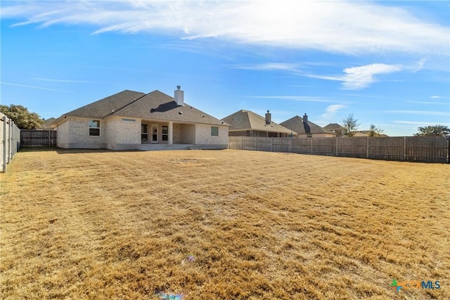 rear view of house featuring a yard