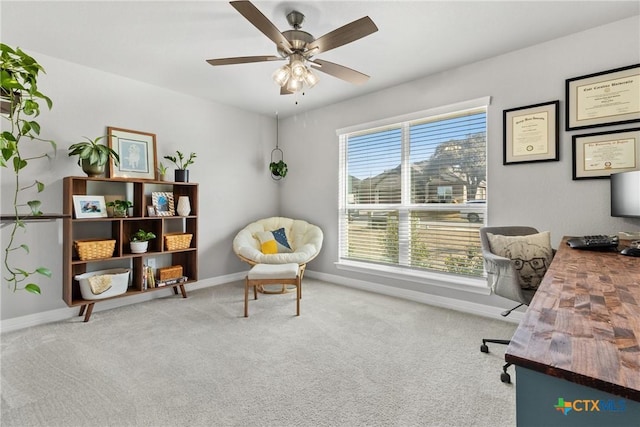 carpeted office space featuring ceiling fan