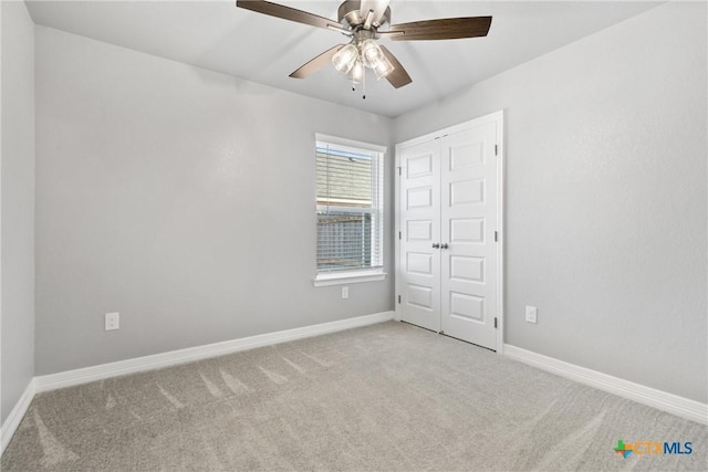 unfurnished bedroom featuring light carpet, ceiling fan, and a closet