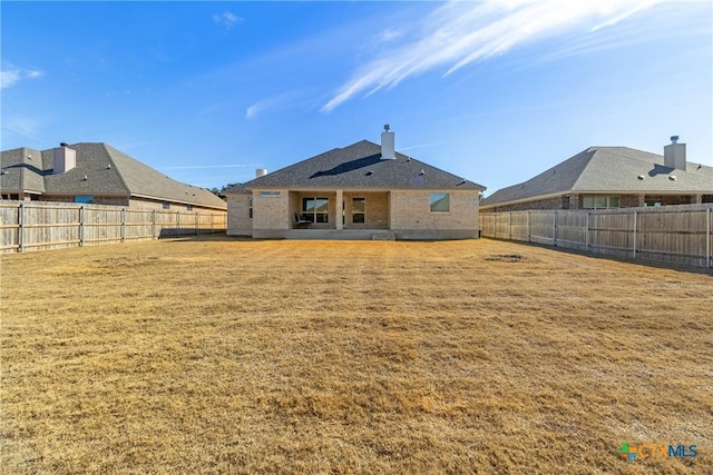 rear view of house with a yard