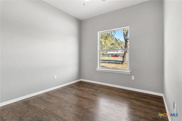 unfurnished room with dark wood-style floors, baseboards, and a ceiling fan