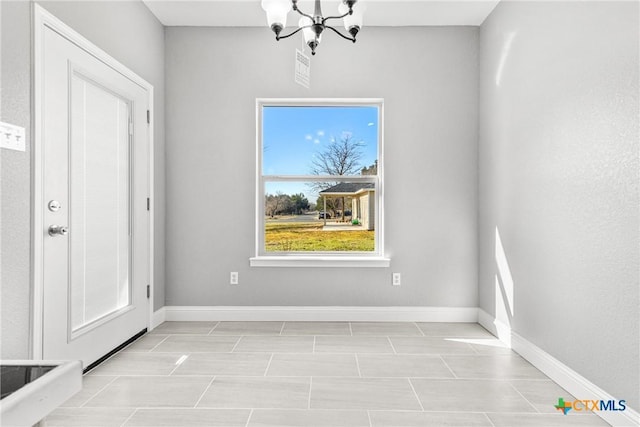 unfurnished dining area featuring a notable chandelier and baseboards