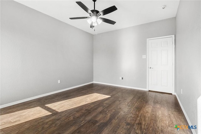 empty room featuring a ceiling fan, baseboards, and dark wood-style flooring