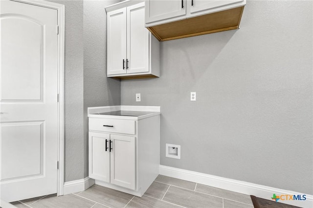 washroom featuring baseboards and a textured wall