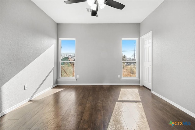 unfurnished room featuring a ceiling fan, dark wood finished floors, and baseboards