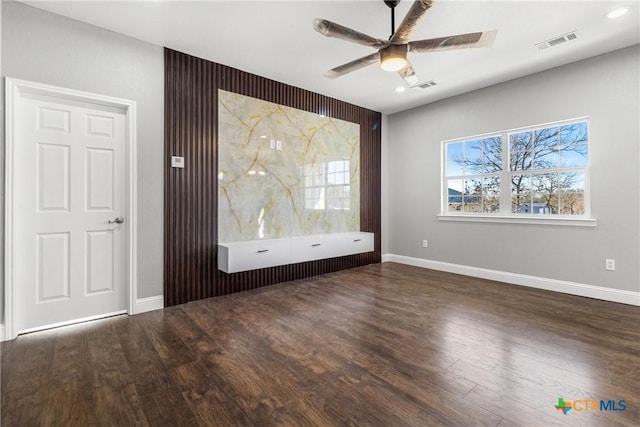 spare room with dark wood-style floors, plenty of natural light, and visible vents