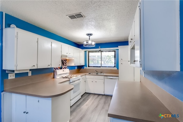 kitchen featuring white cabinets, light hardwood / wood-style flooring, a textured ceiling, and white appliances