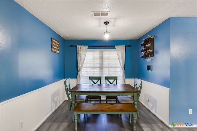 dining room featuring dark hardwood / wood-style flooring and a textured ceiling