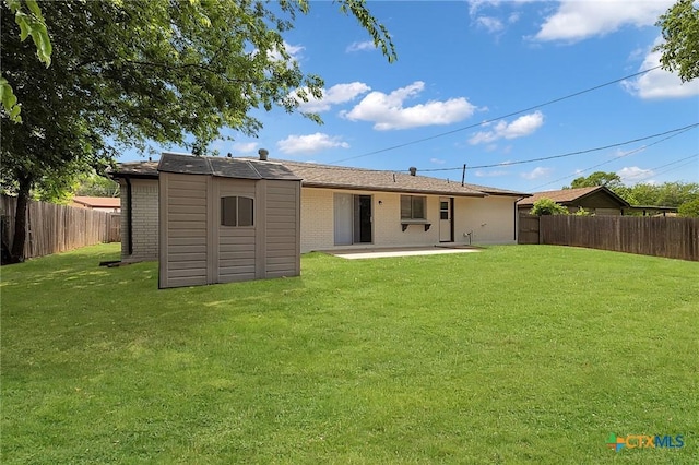 rear view of property featuring a fenced backyard, a shed, a yard, and brick siding