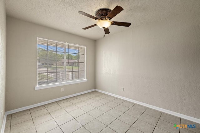 empty room featuring a ceiling fan, light tile patterned floors, and a textured ceiling