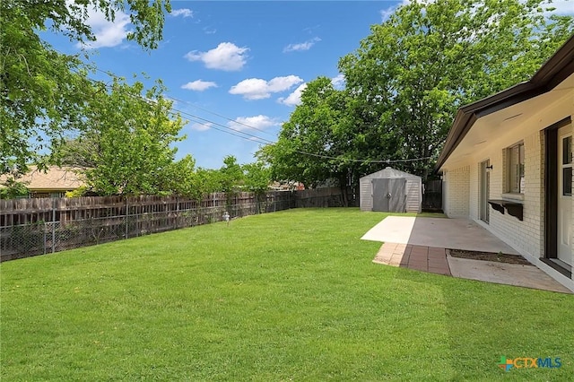 view of yard with a storage shed, a patio area, an outbuilding, and a fenced backyard