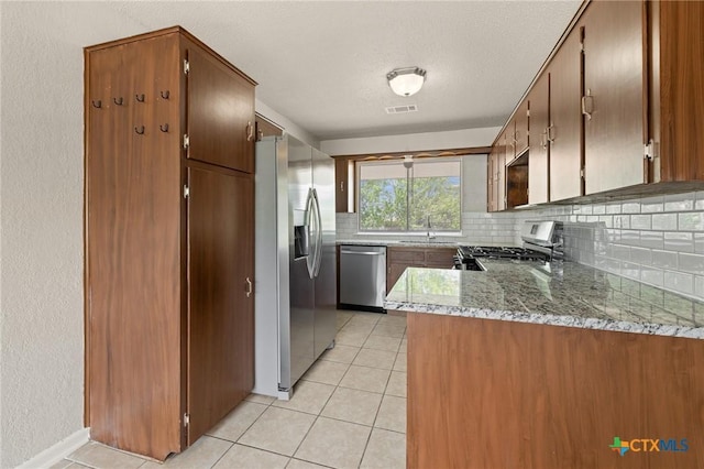kitchen with a sink, visible vents, backsplash, light tile patterned floors, and appliances with stainless steel finishes