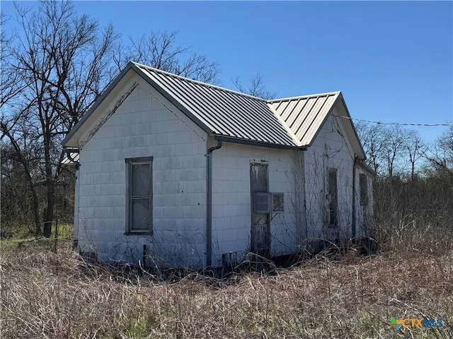 view of side of property featuring metal roof and cooling unit