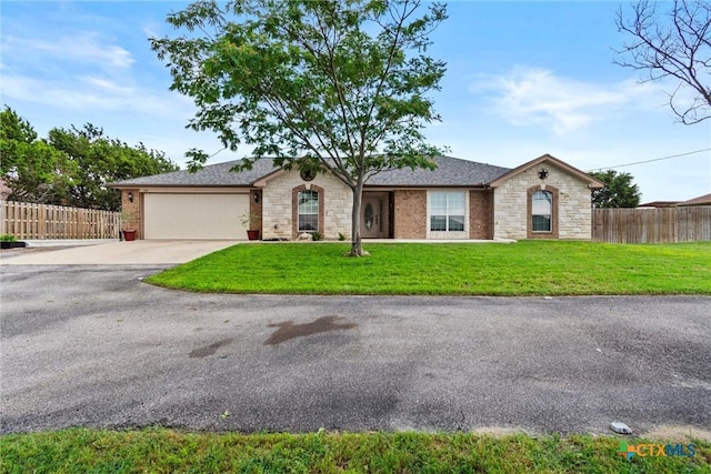 single story home featuring stone siding, driveway, an attached garage, and a front yard
