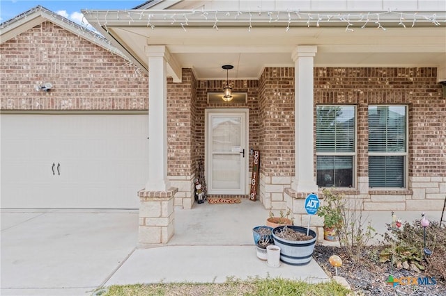 view of exterior entry featuring a garage and a porch