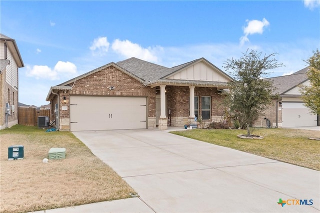 view of front of house with a garage, a front lawn, and central AC