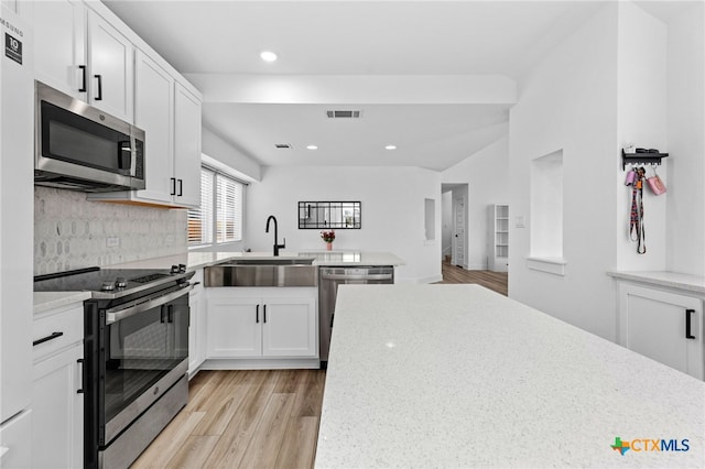 kitchen with stainless steel appliances, sink, light stone countertops, white cabinets, and light wood-type flooring