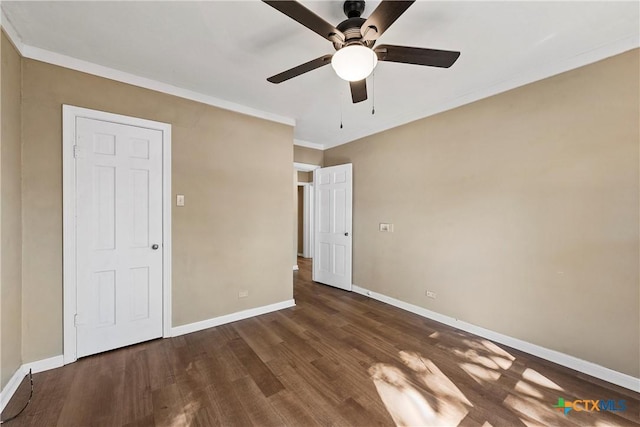 unfurnished bedroom featuring ceiling fan, dark hardwood / wood-style flooring, and crown molding