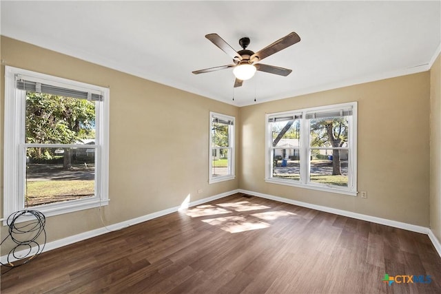 spare room with ceiling fan, plenty of natural light, and dark hardwood / wood-style floors