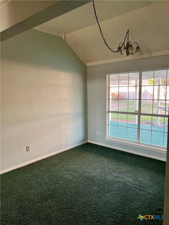 unfurnished room featuring a wealth of natural light, carpet flooring, vaulted ceiling, and baseboards