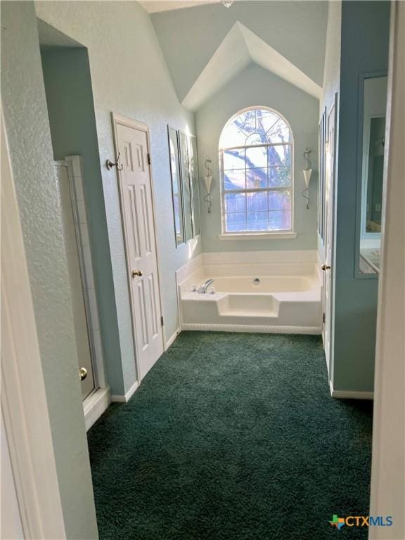 bathroom featuring lofted ceiling, a garden tub, a shower with door, and carpet flooring