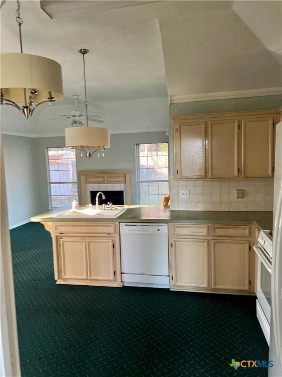 kitchen featuring tasteful backsplash, hanging light fixtures, a sink, white appliances, and a peninsula