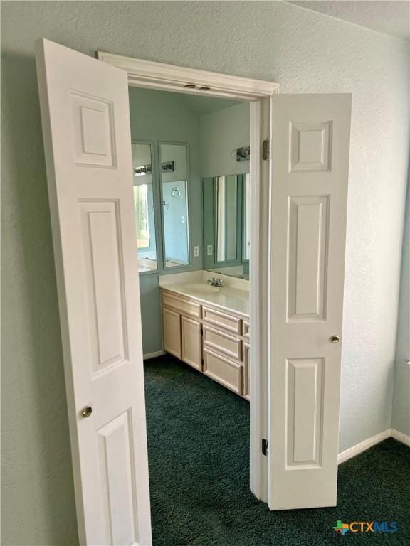 bathroom featuring vanity, baseboards, and a textured wall