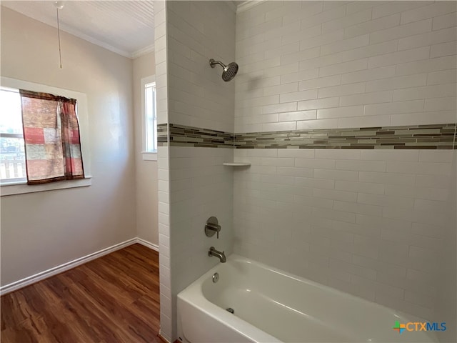 bathroom featuring hardwood / wood-style flooring, tiled shower / bath combo, and ornamental molding