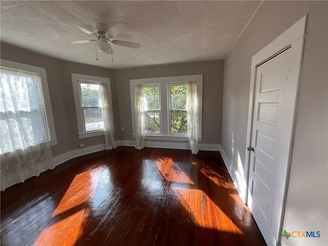 spare room with ceiling fan and dark hardwood / wood-style floors