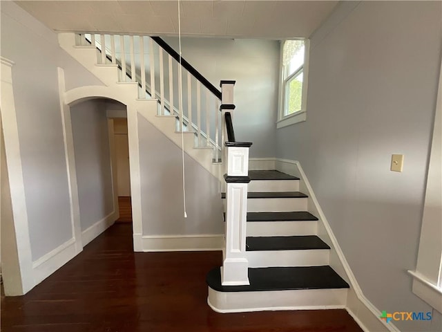 1203 E Third St, Hallettsville, TX 77954 - stairway with wood finished floors, baseboards, and arched walkways