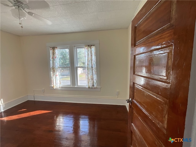 empty room featuring dark wood-type flooring and ceiling fan