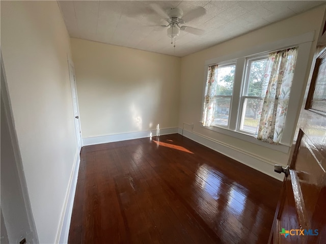 unfurnished room with dark wood-type flooring and ceiling fan