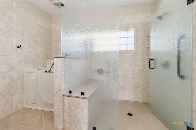 2406 Northwoods Dr, New Braunfels, TX 78132 - bathroom with tile walls, a shower stall, and tile patterned floors