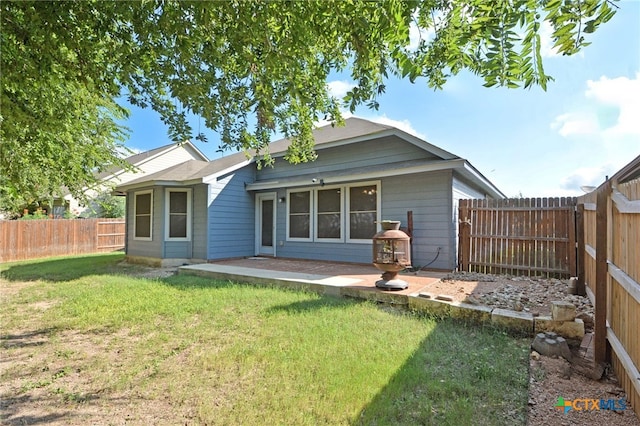 rear view of house with a lawn and a patio area