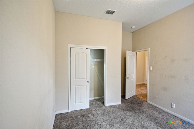 unfurnished bedroom with a closet, carpet floors, and a textured ceiling