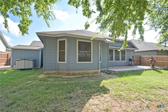 back of property featuring a lawn and a patio