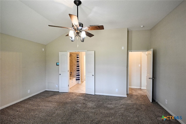 unfurnished bedroom with ceiling fan, ensuite bathroom, light colored carpet, and lofted ceiling