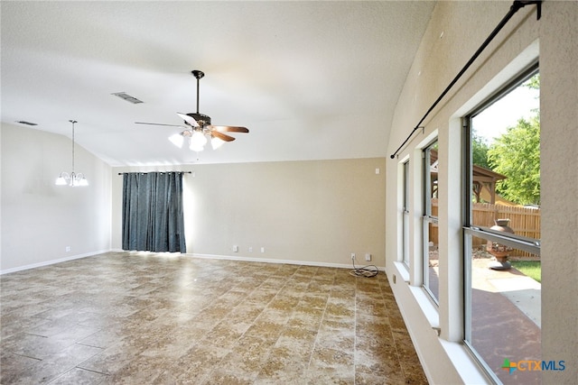 spare room with ceiling fan with notable chandelier and vaulted ceiling