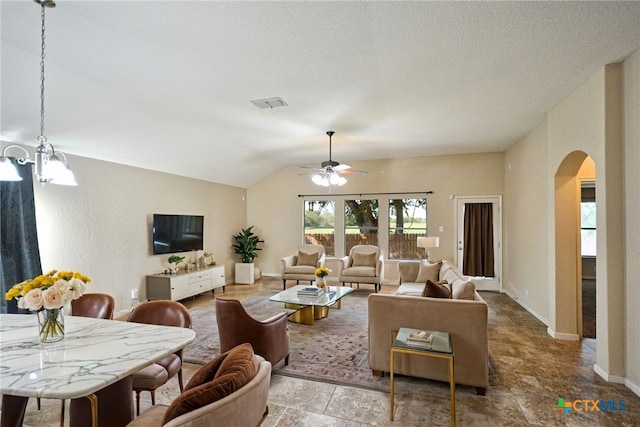 living room featuring ceiling fan with notable chandelier and lofted ceiling