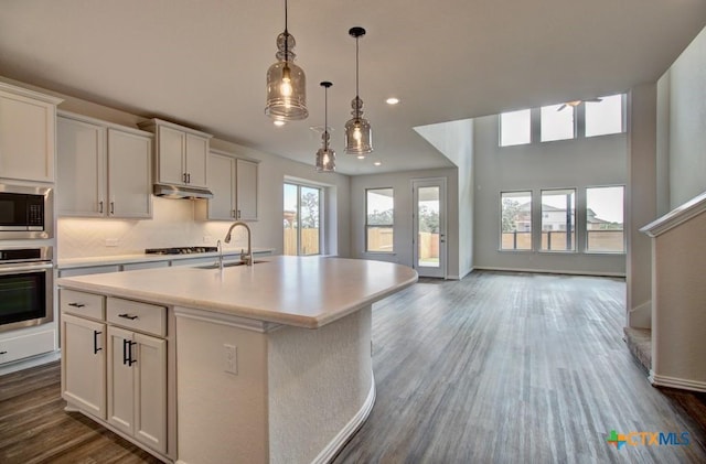 kitchen with sink, white cabinetry, appliances with stainless steel finishes, and a kitchen island with sink