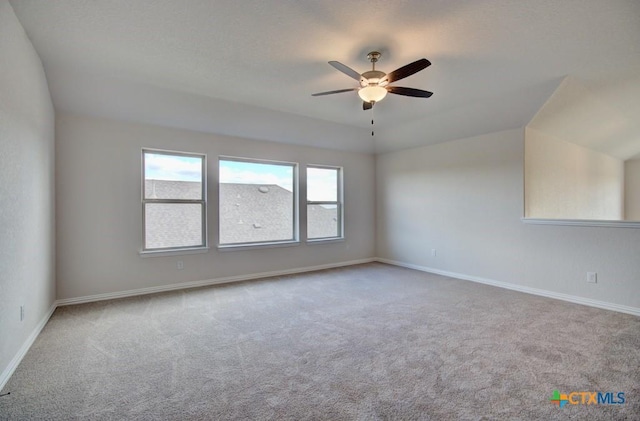 spare room featuring ceiling fan, light carpet, and lofted ceiling