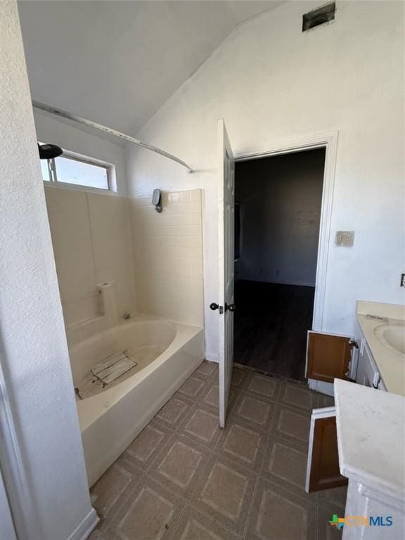 bathroom with shower / tub combination, vanity, and vaulted ceiling