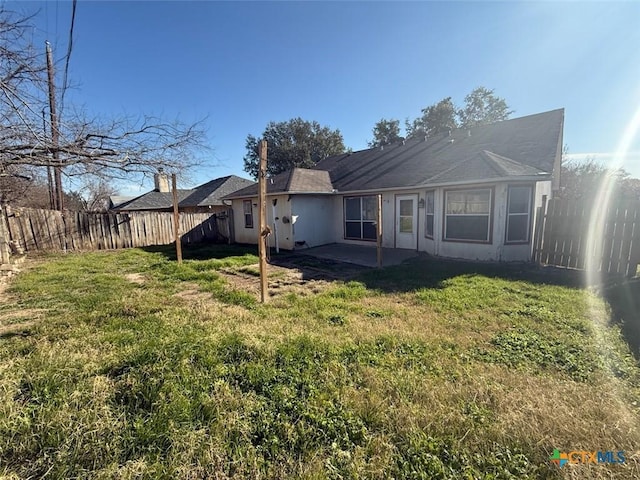 back of house featuring a patio area and a yard