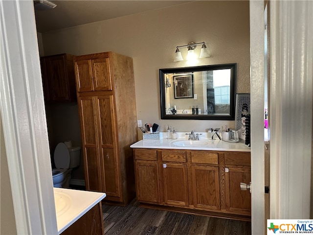 bathroom featuring wood-type flooring, toilet, and vanity