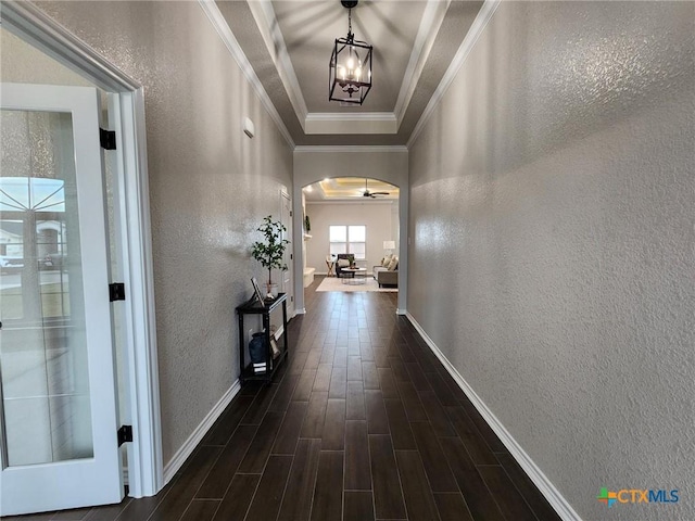 hallway with dark hardwood / wood-style flooring, a chandelier, and ornamental molding